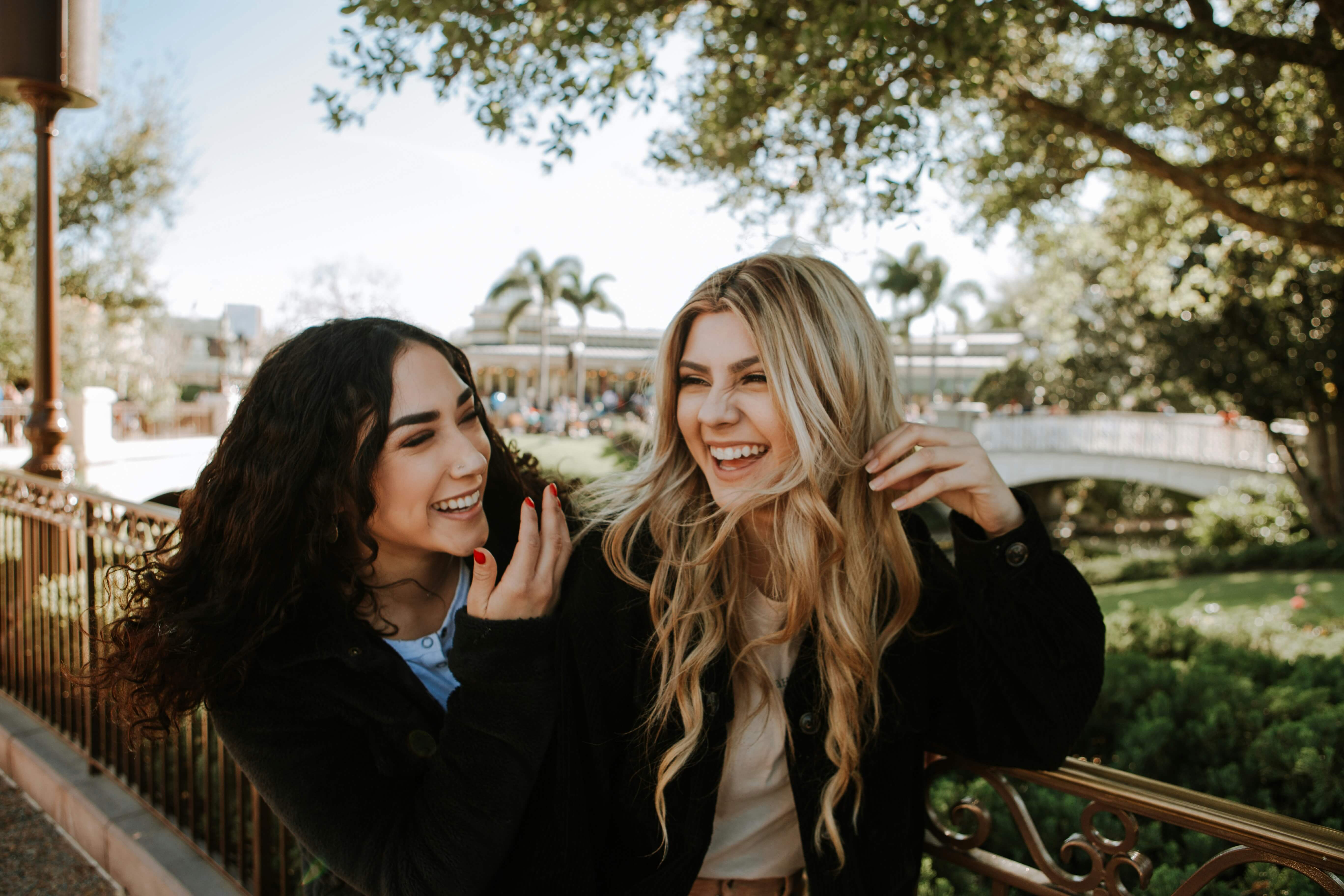 Duas amigas sorrindo juntas em momento de cumplicidade