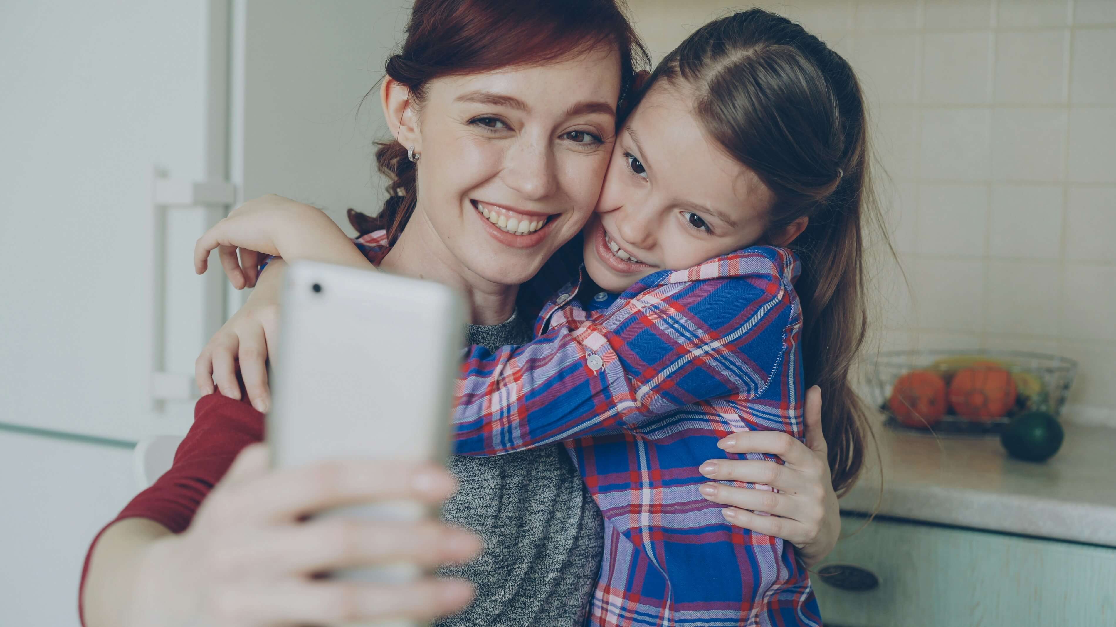 Mãe e filha abraçadas sorrindo
