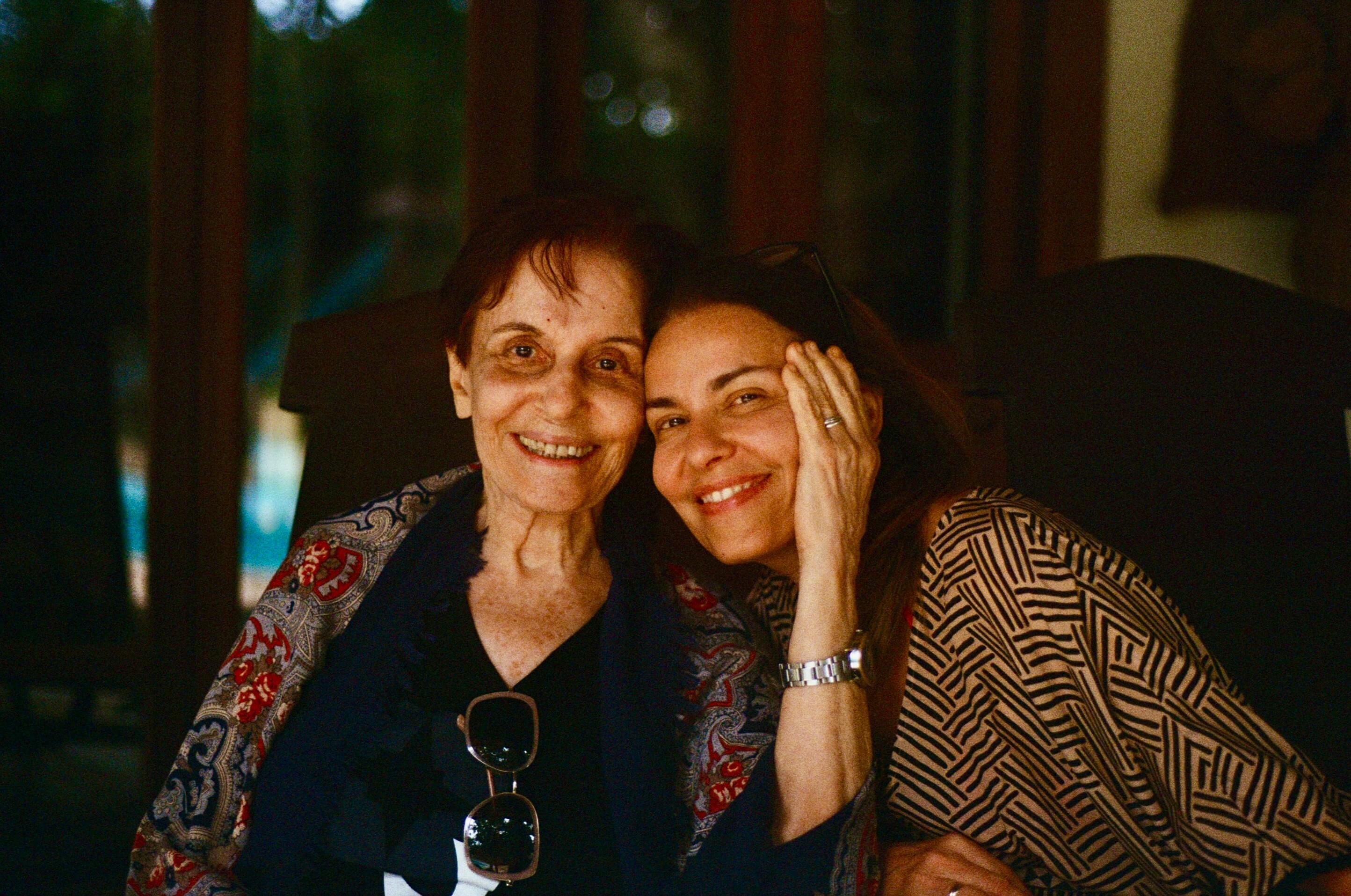 Neta abraçando a avó sorridente em momento de carinho