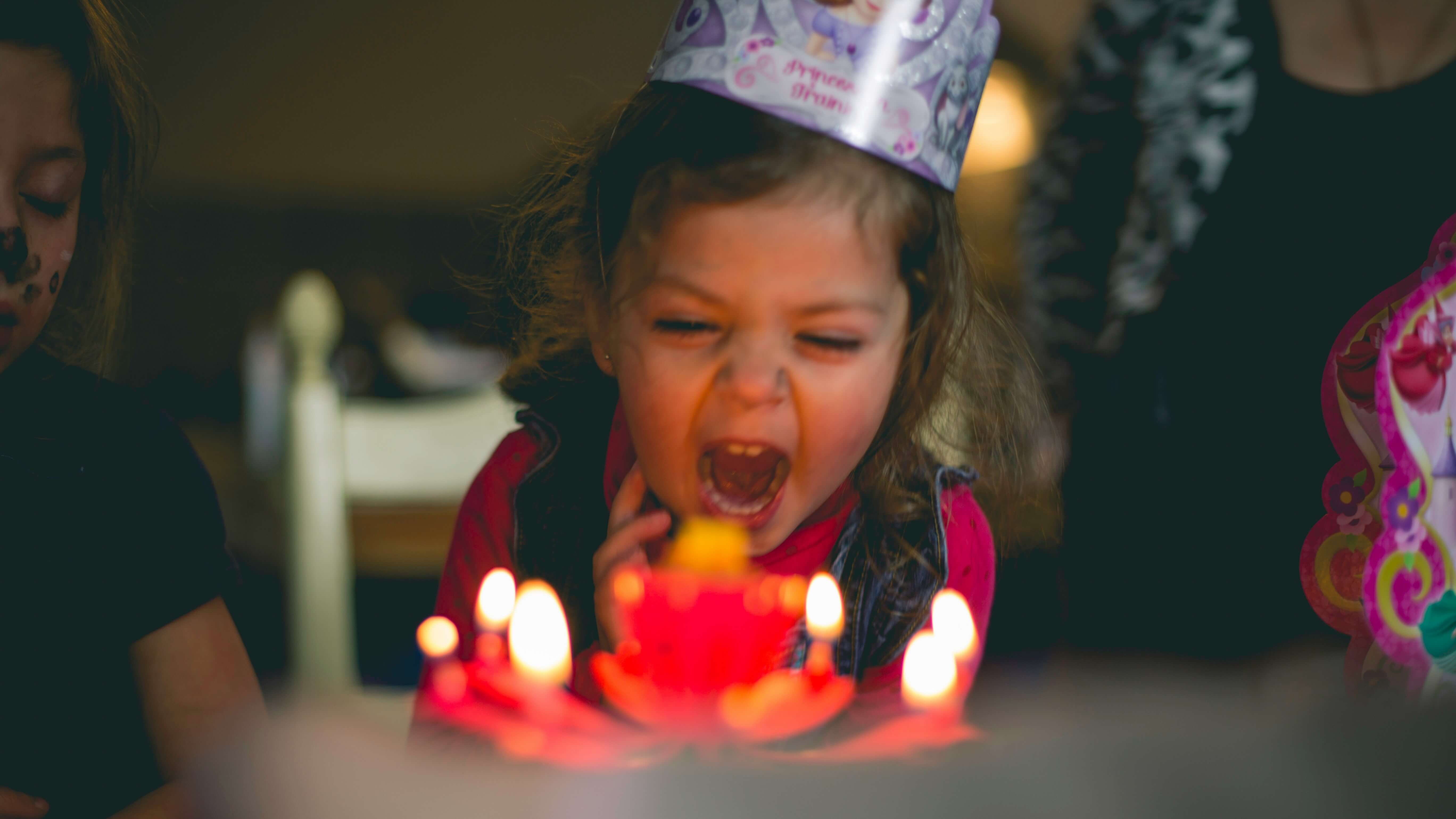 Menina comemorando aniversário com bolo e velas